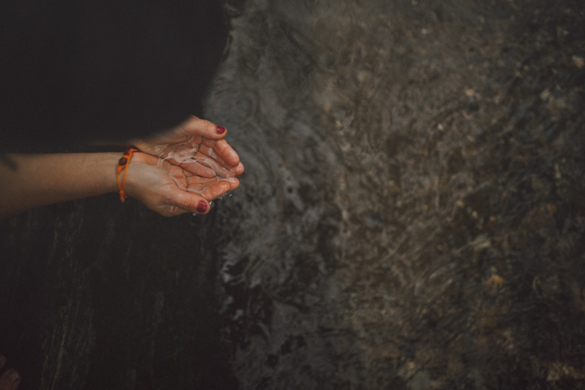manos sosteniendo agua en un rio