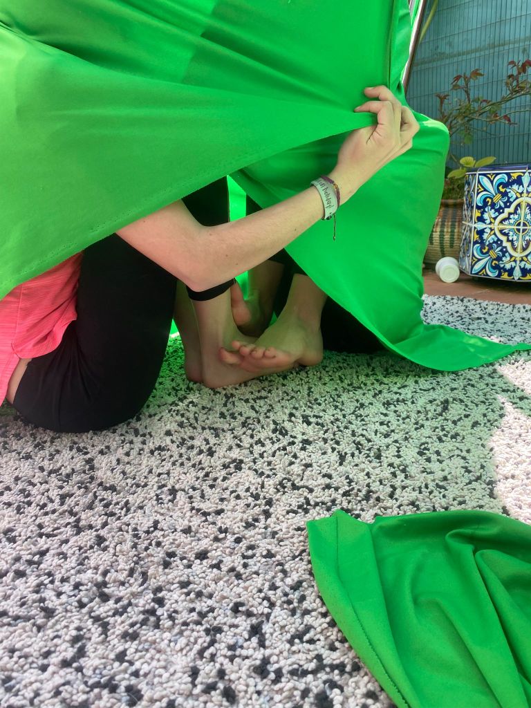 se ven dos niñas escondidas adentro de la tela