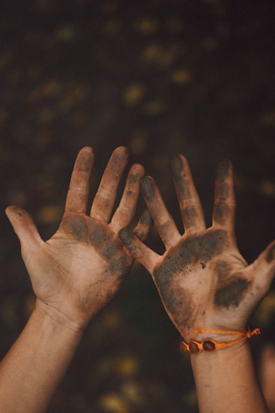 se ven mis manos llenas de tierra y los pies en el piso